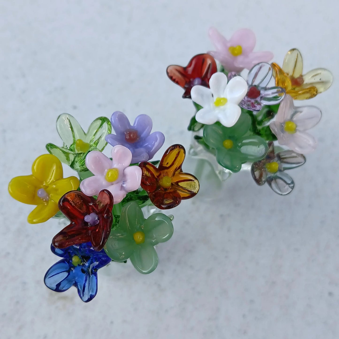 Close-up of handmade miniature glass flowers, showing detailed petals and vibrant colors