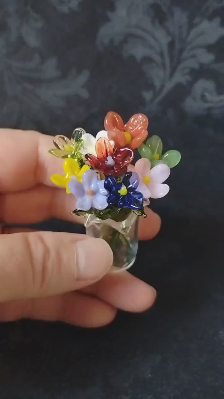 video showing miniature glass flowers in a glass vase, showing size and the colorful bouquet of flowers