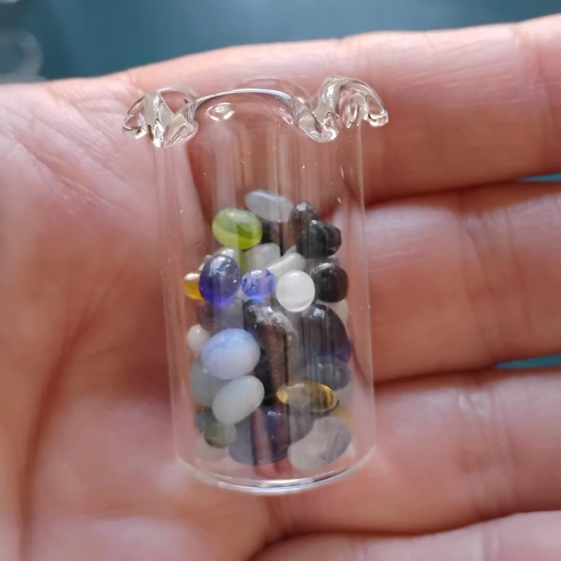 miniature glass vase with vase filled with colorful glass beads.