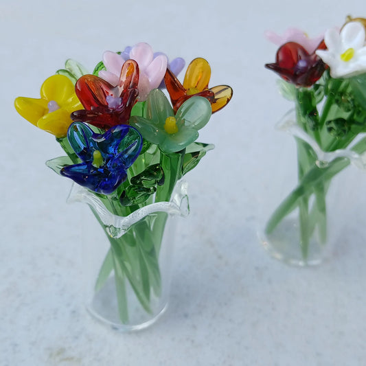 Two miniature glass vases with multicolored handmade lampwork flowers displayed side by side