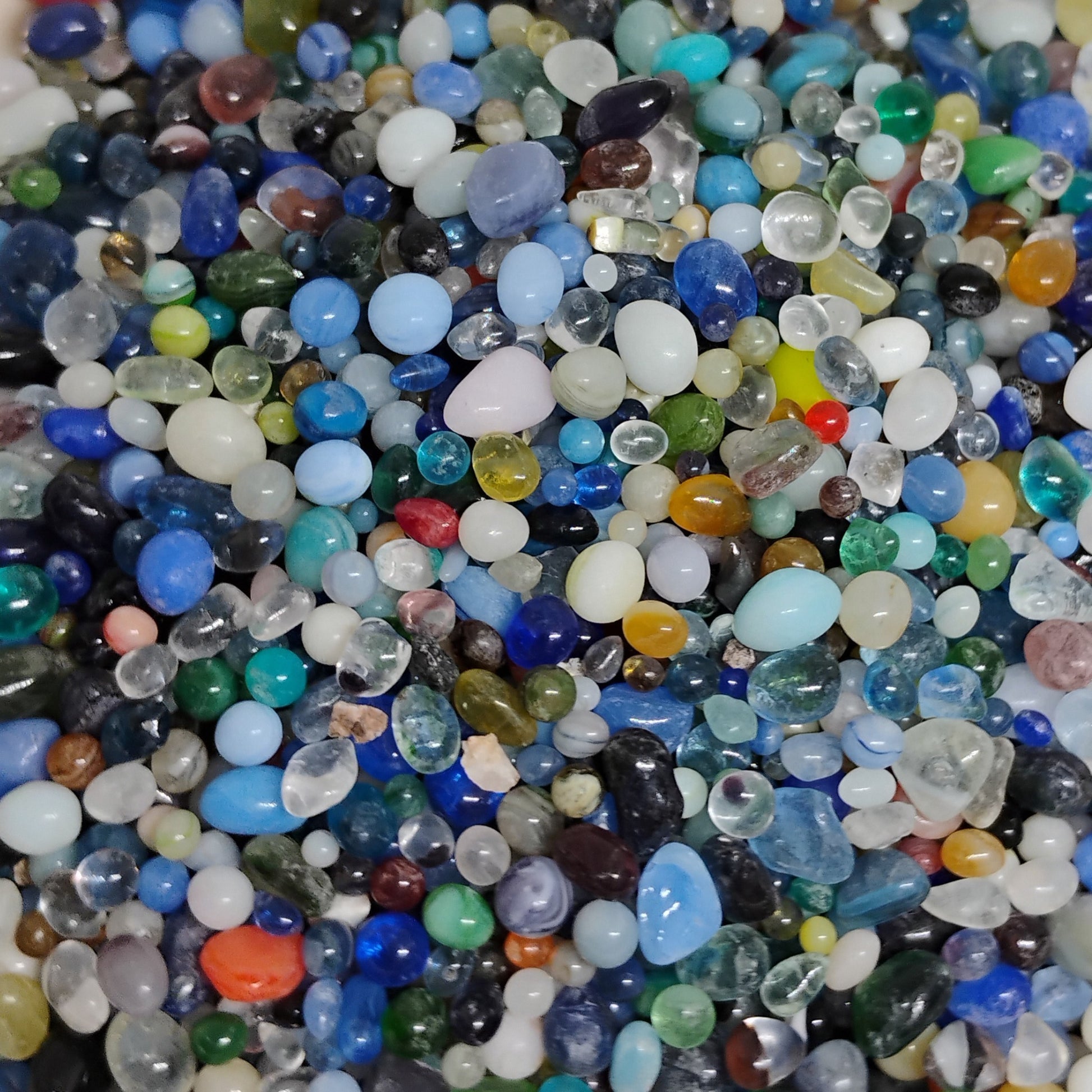 Random mix of colorful miniature glass beads in a packet, perfect as vase filler for tiny glass flower arrangements.